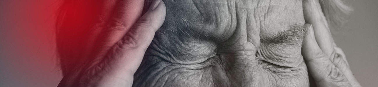 Fotografía de un hombre mayor con la cabeza entre las manos, relacionada con una demanda por lesión cerebral traumática.