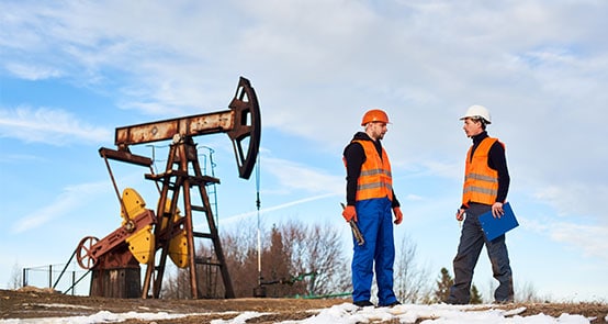 Fotografíagrafía de trabajadores de un campo petrolero en un sitio de trabajo relacionado con los riesgos de accidentes laborales.